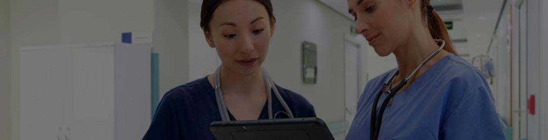 Two healthcare workers looking at tablet computer